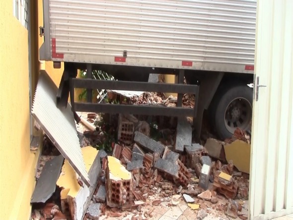 Caminhão destruiu o muro e ainda atingiu a casa (foto: Josafá Rodrigues/TV Poços).