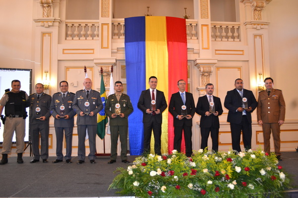 Autoridades da área de segurança pública recebem o troféu.