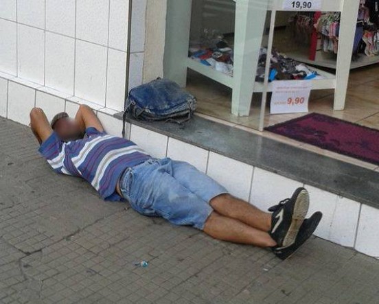 Homem fica deitado em frente a loja próxima ao Terminal de LInhas Urbanas.